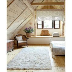 an attic bedroom with white carpet and wooden walls