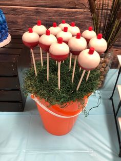 there is a potted plant with red and white cupcakes on sticks in it