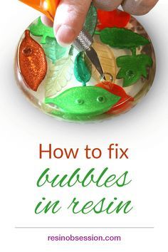 a hand is holding scissors over a bowl filled with fish and carrots, while the text reads how to fix bubbles in resin