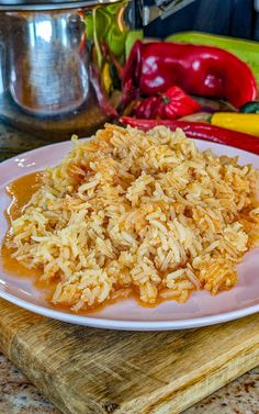 rice on a plate with sauce and peppers in the background