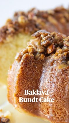 a bundt cake with walnuts on top is sitting on a white plate and ready to be eaten