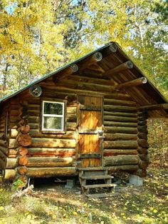 a log cabin in the woods with logs stacked on it's roof and windows