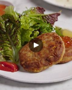 a white plate topped with meat patties covered in ketchup and lettuce