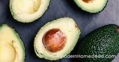 four avocados cut in half on a table