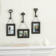 three pictures hanging on the wall with two key hooks