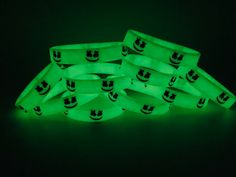 glow in the dark bracelets with smiley faces on them are glowing green and black