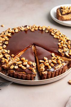 there is a chocolate pie with nuts on the top and one slice missing from it