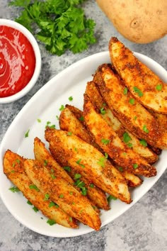 fried potato wedges on a plate with ketchup and parsley next to it