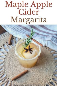 an apple cider margarita is garnished with rosemary and cinnamon on the side