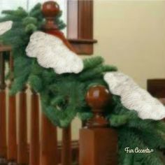 a christmas garland on the banisters of a house with white and green decorations