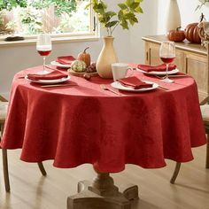 a dining table with red linens and place settings