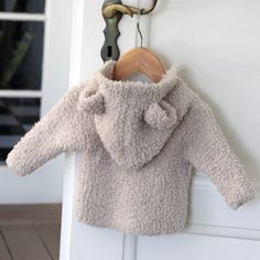 a teddy bear coat hanging on a door