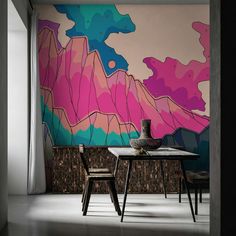 a dining room table with two chairs in front of a colorful wall mural on the wall