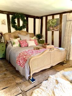 a large bed sitting inside of a bedroom on top of a wooden floor next to a window