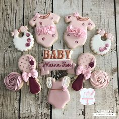 baby shower cookies are arranged on a wooden table