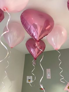 some pink balloons are hanging from the ceiling