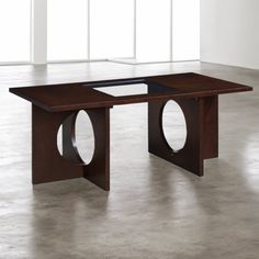 a table that has some sort of circular design on the top and bottom, in an empty room