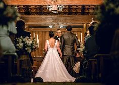 a bride and groom walking down the aisle at their wedding ceremony in an old church