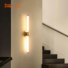 a wall light that is on the side of a stair case next to some stairs