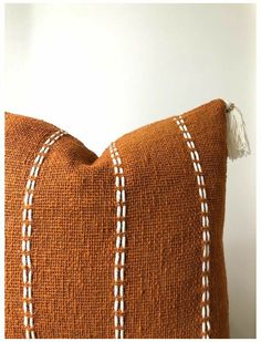 an orange pillow with white stitching on it