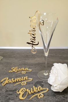 a wine glass with the word garni on it next to a white flower