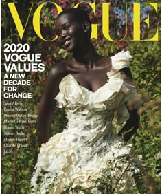 a woman in a white dress on the cover of a magazine, with bushes behind her