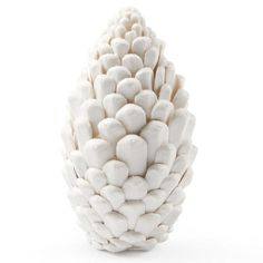 a white vase filled with lots of rocks on top of a white flooring area