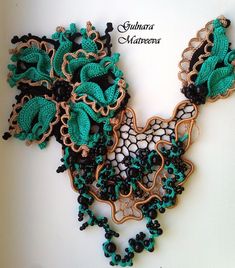 an intricately decorated necklace with green and black beads