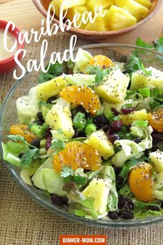 a salad with oranges, lettuce and other vegetables in it on a table