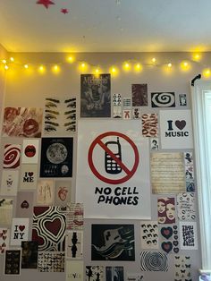 a wall covered in posters and lights with no cell phones sign on the back ground