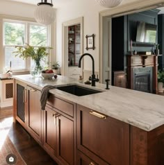 an instagramted photo of a kitchen with wood cabinets and marble counter tops, along with the words instagram