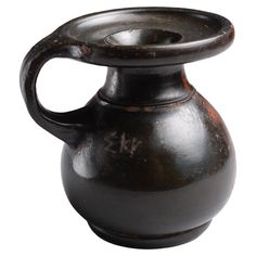 an old black vase is shown on a white background