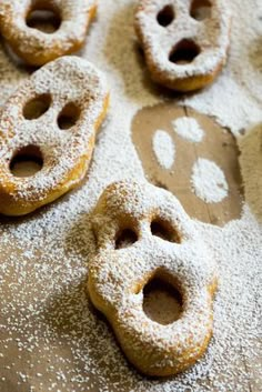 powdered sugar covered doughnuts are arranged on a baking sheet with holes in the middle