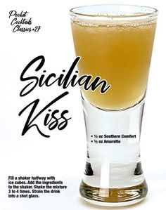 a glass filled with liquid sitting on top of a white table next to an advertisement for sicilian kiss