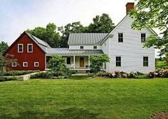 a large white house sitting in the middle of a lush green field next to trees