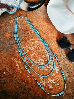 Triple Strand Turquoise And Navajo Inspired Necklace | Gussied Up Online Boutique Elevate your look with our Triple Strand Turquoise And Navajo Inspired Necklace! Handmade with tiny 4mm synthetic turquoise, this 3-strand necklace comes in varying lengths (26", 30", 36"), with a 5" extender for versatility. The clustered navajo pearl and turquoise add a touch of elegance. Nickel, lead, and chrome free for worry-free wear. Women's Western Wear, Trending Jewelry, Western Boutique, Western Wear For Women, Inspired Necklace, Sterling Jewelry, Wedge Heel Sandals, Western Jewelry, Women's Wear