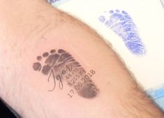 a close up of a person's arm with a baby foot print on it