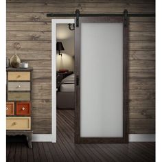 an open door leading to a bedroom with wooden walls and flooring in the background