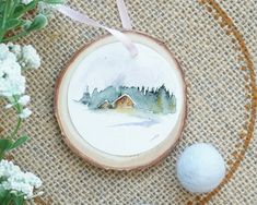 an ornament with a house on it next to flowers and a golf ball