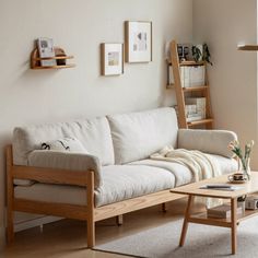 a living room with a white couch and wooden coffee table in front of a window