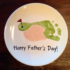 a white plate with a handprinted image of a golf ball on it that says happy father's day