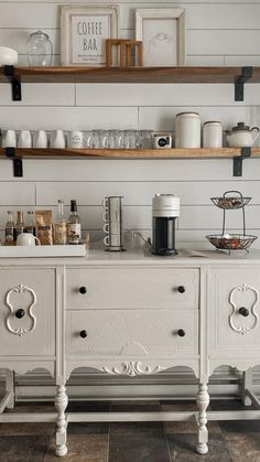 a kitchen with white painted furniture and open shelving above the countertop is shown