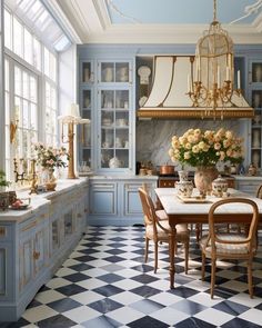 a kitchen with blue cabinets and checkered flooring, chandelier above the dining room table