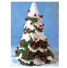 a crocheted christmas tree with red and white balls on it's top