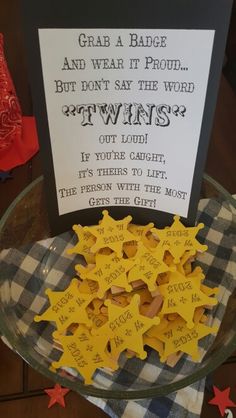 a glass bowl filled with yellow stars next to a sign that says, grab a badge and wear it proud but don't say the word