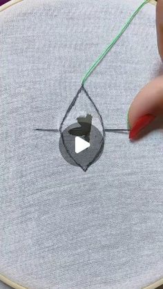 someone is stitching something on the back of a piece of fabric with a needle