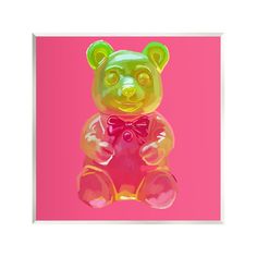 a colorful teddy bear sitting on top of a pink background