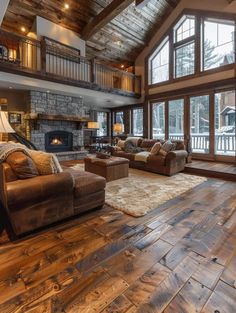 a living room filled with furniture and a fire place in the middle of an open floor plan