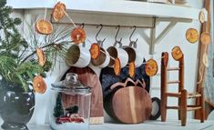 pots and pans are hanging on the wall next to a potted pine tree