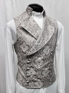 An elegant double breasted vest for formal occasions. A fitted vest made in rich silver brocade fabric with grey and black stitched designs on it. The vest has a stand up to collar and wide sweeping lapels. Fastens on the inside with a sturdy button and buttons on the outside with five engraved metal buttons. The vest back and inside lining is made from rich black satin. Comes in sizes small-XXXL. Wonderful Note: This vest is very fitted check the measurements for each size below carefully befor Fitted Vest, Double Breasted Vest, Enchanted Evening, Waist Coat, Engraved Metal, Vest Coat, Wedding Dress Sleeves, Brocade Fabric, Mens Vest